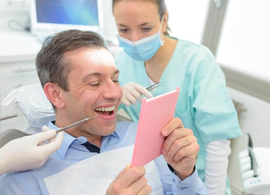 Male Checking Teeth in Mirror