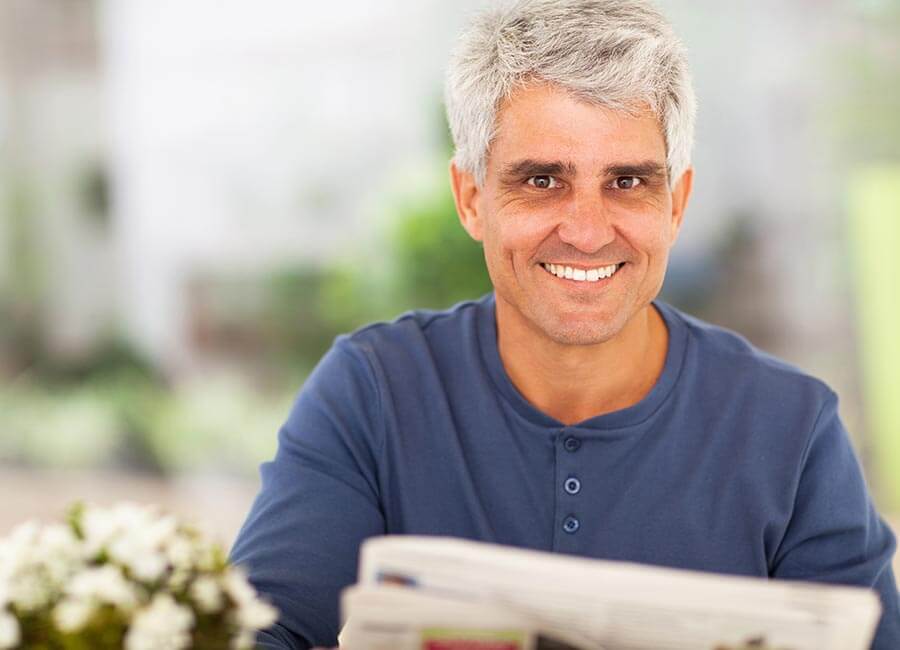 Gentleman Smiling Whilst Reading Newspaper